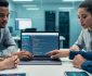 Web development team reviewing clean HTML code and accessibility compliance practices on a laptop in a modern office setting.