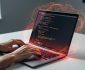 Developer’s hands typing on a laptop with subtle red and orange glow suggesting Rust’s memory-safe programming concepts